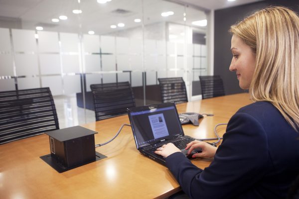 A woman on a laptop in an office setting.