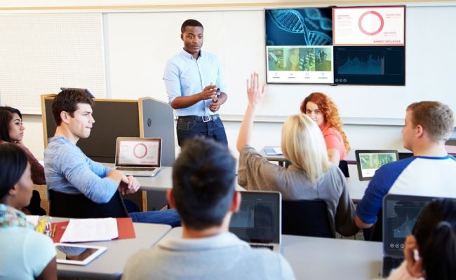 A teacher and his students interacting in a smart classroom.